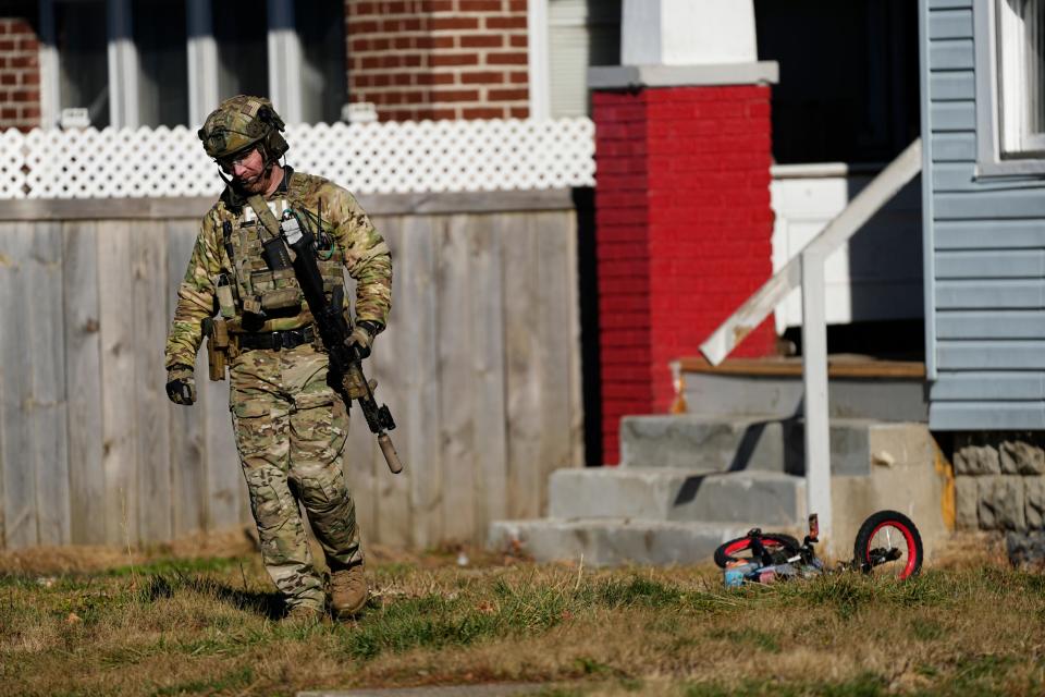 An FBI agent walks outside a house on Racine Avenue after a shooting occurred at the property earlier Wednesday morning.