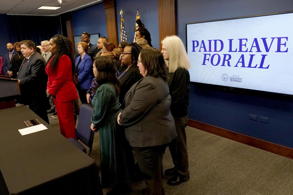 Illinois Gov. J.B. Pritzker, right, talks about the merits of the Paid Leave For All Workers Act before signing it into law on Monday, March 13, 2023, in Chicago. Illinois became one of three U.S. states to require employers to offer paid time off for any reason starting in January of 2024. (AP Photo/Charles Rex Arbogast)