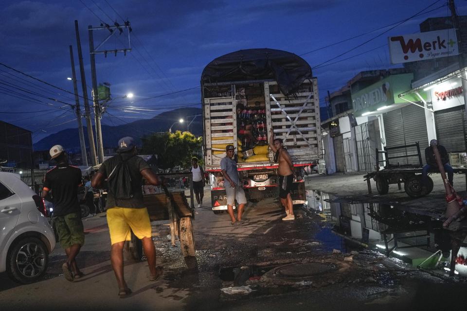 Men wait to unload a truck at the La Parada neighborhood, near the border with Venezuela, in Cucuta, Colombia, Friday, Aug. 5, 2022. The border will gradually reopen after the two nations restore diplomatic ties when Colombia's new president is sworn-in on Aug. 7, according to announcement in late July by Colombia's incoming Foreign Minister Alvaro Leyva and Venezuelan Foreign Minister Carlos Faria. (AP Photo/Matias Delacroix)