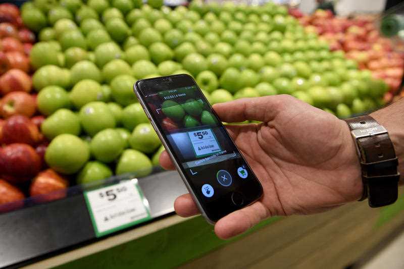 Woolworths' employee Bryn Rayfield uses the company's new Scan & Go app at the Double Bay store in Sydney.