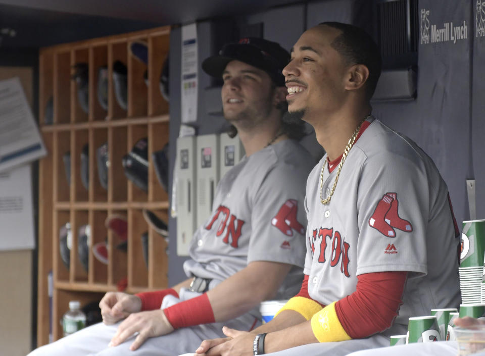 Red Sox outfielders Andrew Benintendi and Mookie Betts in the dugout. (AP)