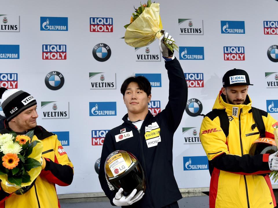 Skeleton racer Yun sung-bin raises a bouquet with his left hand