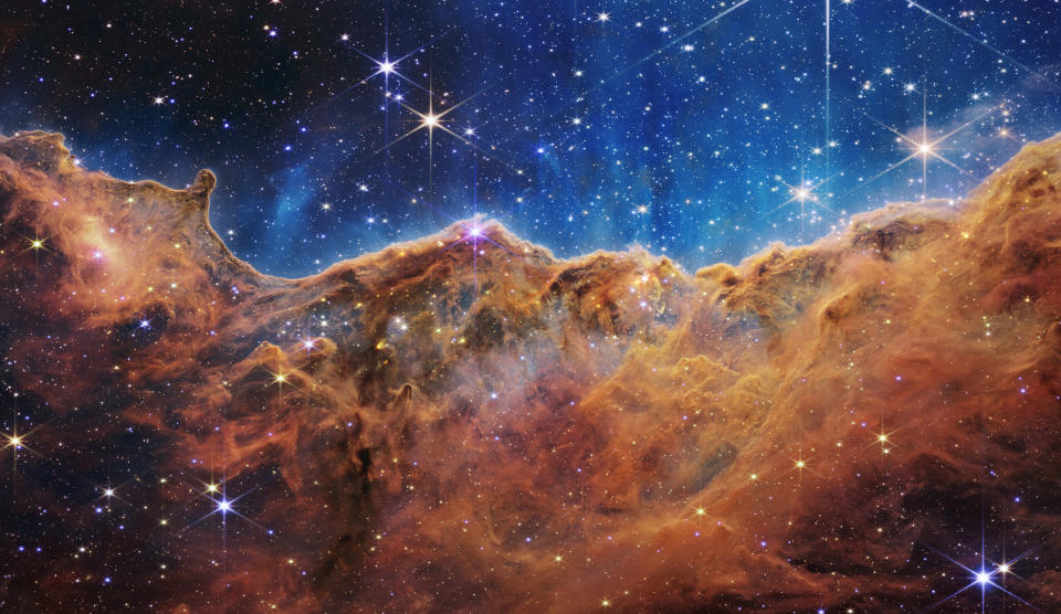 IN SPACE - JULY 12: In this handout photo provided by NASA, a landscape of mountains and valleys speckled with glittering stars is actually the edge of a nearby, young, star-forming region called NGC 3324 in the Carina Nebula, on July 12, 2022 in space. Captured in infrared light by NASA's new James Webb Space Telescope, this image reveals for the first time previously invisible areas of star birth.  (Photo by NASA, ESA, CSA, and STScI via Getty Images)