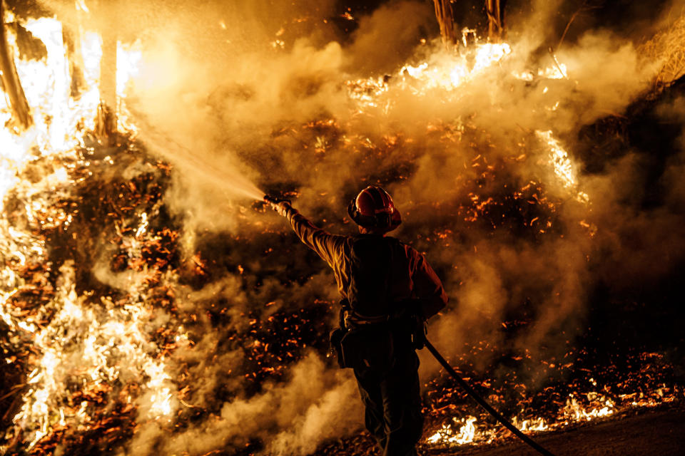 A firefighter sprays water while battling the spread of the Maria Fire as it moved quickly towards Santa Paula, California, on Nov. 1, 2019.&nbsp; (Photo: Marcus Yam/Los Angeles Times via Getty Images)