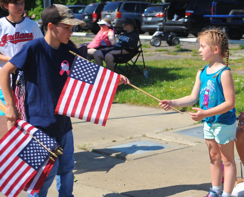 Nori Daily receives an American flag during the Alliance Memorial Day Parade on May, 30, 2022.