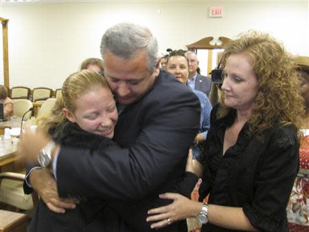 Suspended Liberty County Sheriff Nick Finch hugs his 16-year-old daughter Amber as his wife, Angela Finch (R), approaches after his acquittal on charges of official misconduct and falsifying official documents in Tallahassee, Florida October 31, 2013. REUTERS/Bill Cotterell