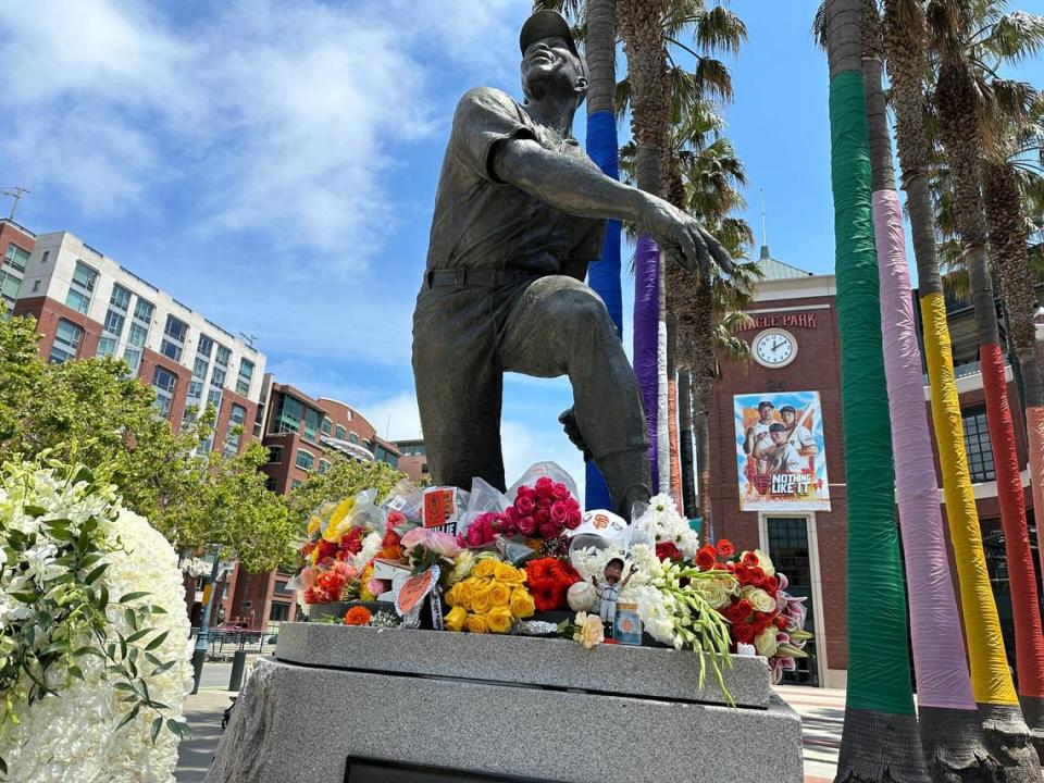Flowers accumulate at the base of the Willie Mays statue outside Oracle Park in San Francisco on Wednesday.