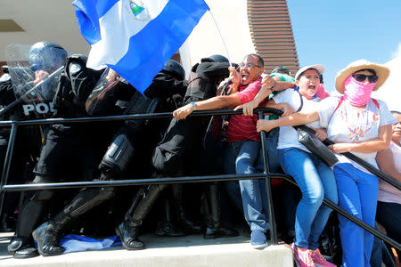 Riot police try to detain protesters during a march called "United for freedom" against Nicaraguan President Daniel Ortega in Managua, Nicaragua October 14, 2018. REUTERS/Oswaldo Rivas