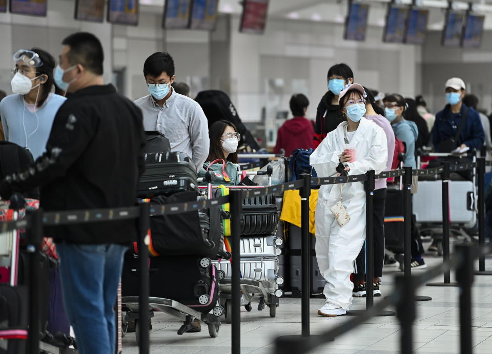 People line up and check in for an international flight at Pearson International airport during the COVID-19 pandemic in Toronto on Wednesday, Oct. 14, 2020.  (Nathan Denette/The Canadian Press via AP)