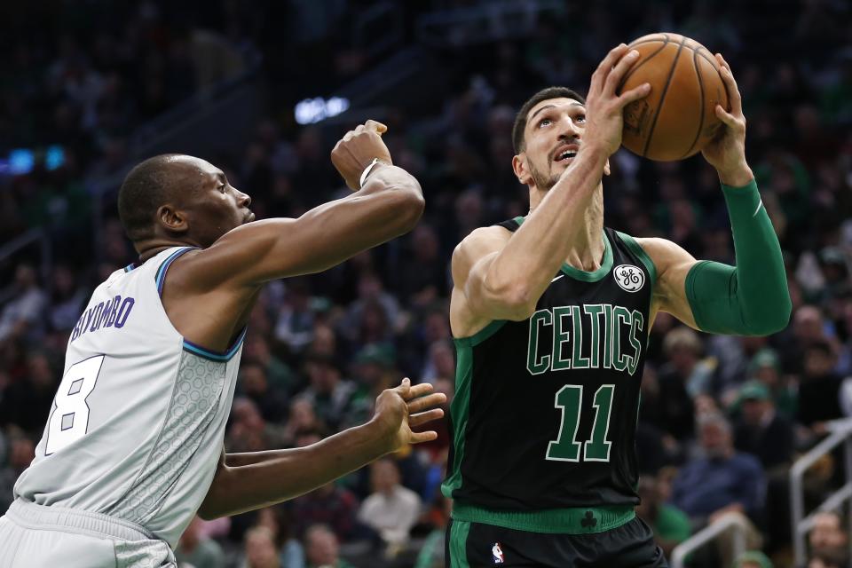 Boston Celtics' Enes Kanter (11) shoots against Charlotte Hornets' Bismack Biyombo (8) during the first half of an NBA basketball game in Boston, Sunday, Dec. 22, 2019. (AP Photo/Michael Dwyer)