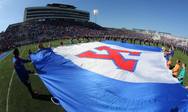 Fans hold a University of Kansas school flag during the playing of the nation anthem prior to a game.