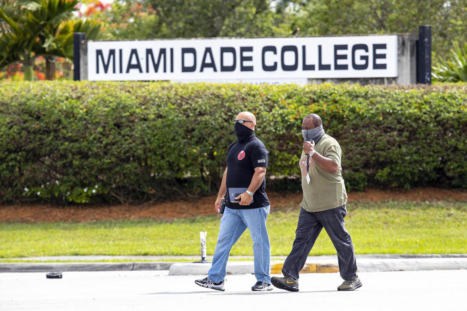 Detectives cross the street near the Miami-Dade Kendall Campus in Miami, Fla., on Sunday, June 6, 2021. Three people are dead and at least six others injured following a shooting at a Florida graduation party, the latest in a string of such violence in the Miami area, police said Sunday. One of those killed was a state corrections officer, Miami-Dade police Director Freddie Ramirez told news outlets. (Daniel A Varela/Miami Herald via AP)