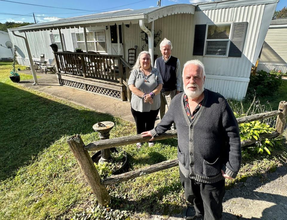Roland L'Heureux stands by his mobile home in Lincoln with real estate agents Lydia Smith and Ed Stachurski.