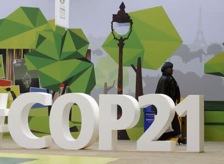 A woman walks past the COP21 logo in the Climate Generations area during the World Climate Change Conference 2015 (COP21) at Le Bourget, near Paris, France, December 1, 2015. REUTERS/Jacky Naegelen