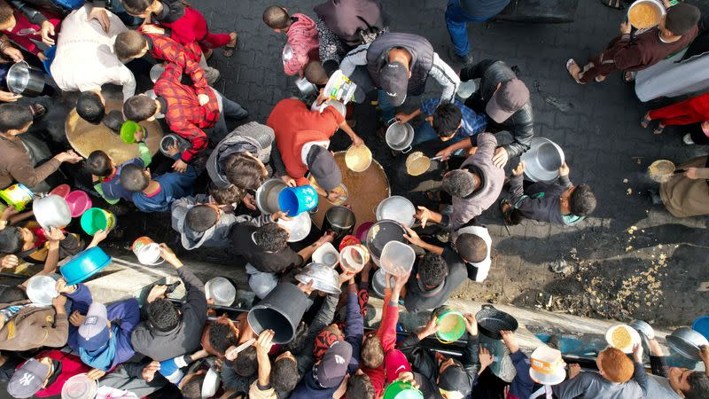 FOTO DE ARCHIVO. Palestinos se reúnen para recibir alimentos preparados por una cocina de caridad, en medio del actual conflicto entre Israel y el grupo islamista palestino Hamás, en Ráfah, en el sur de la Franja de Gaza