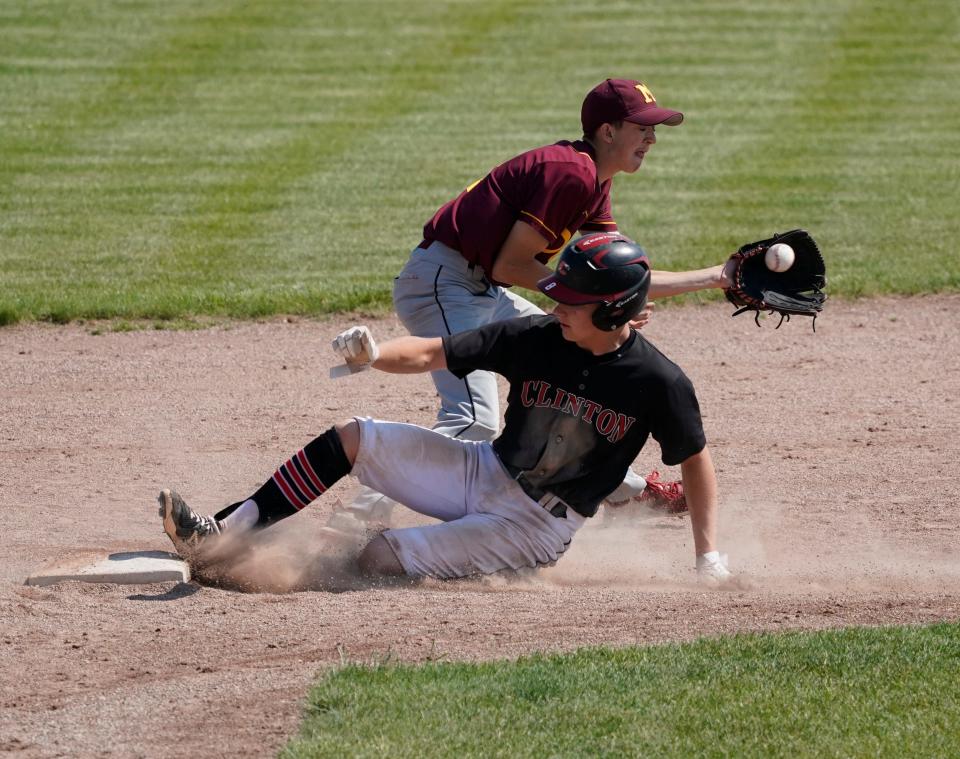 Clinton's Derek Tomalak, foreground, slides safely into second base ahead of the throw during Clinton's Division 3 district championship game against Manchester on Saturday.
