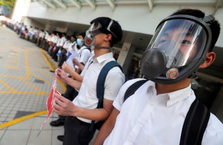 Secondary school students wearing masks join a human chain protesting against what they say is police brutality against protesters, after clashes at Wan Chai district in Hong Kong