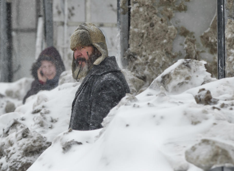 People wait in a snowed in bus stop during a blizzard in Bucharest, Romania, Wednesday, Jan. 29, 2014. Weather forecasters issued a code red severe weather warning as a second wave of blizzards affects the southeastern regions of Romania disrupting road and rail traffic.(AP Photo/Vadim Ghirda)