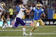 UCLA quarterback Dorian Thompson-Robinson (1) stiff-arms Washington linebacker Carson Bruener during the second half of an NCAA college football game Friday, Sept. 30, 2022, in Pasadena, Calif. (AP Photo/Marcio Jose Sanchez)