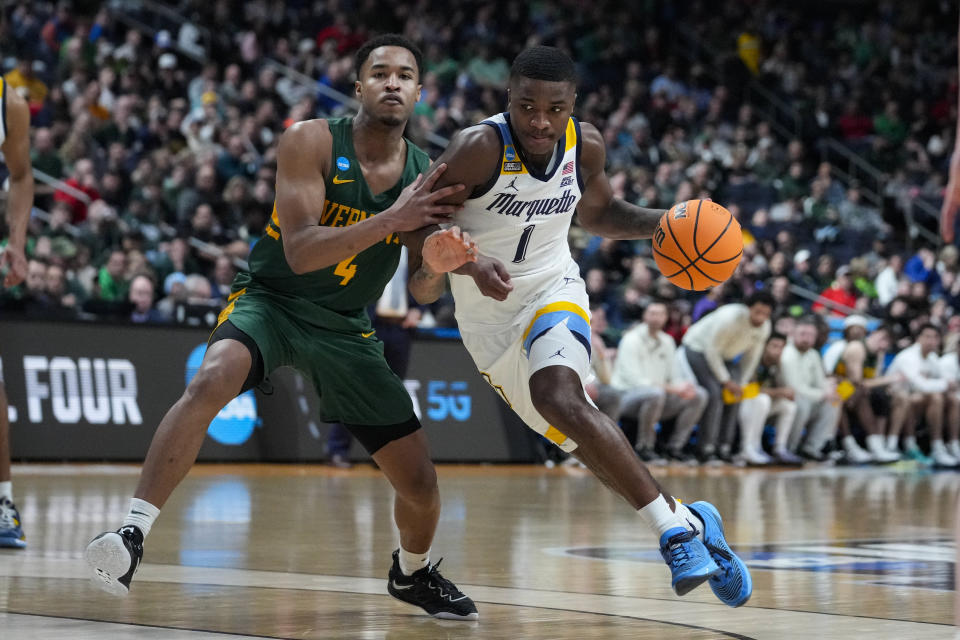 Marquette guard Kam Jones (1) drives on Vermont guard Kameron Gibson (4) in the second half of a first-round college basketball game in the men's NCAA Tournament in Columbus, Ohio, Friday, March 17, 2023. (AP Photo/Michael Conroy)