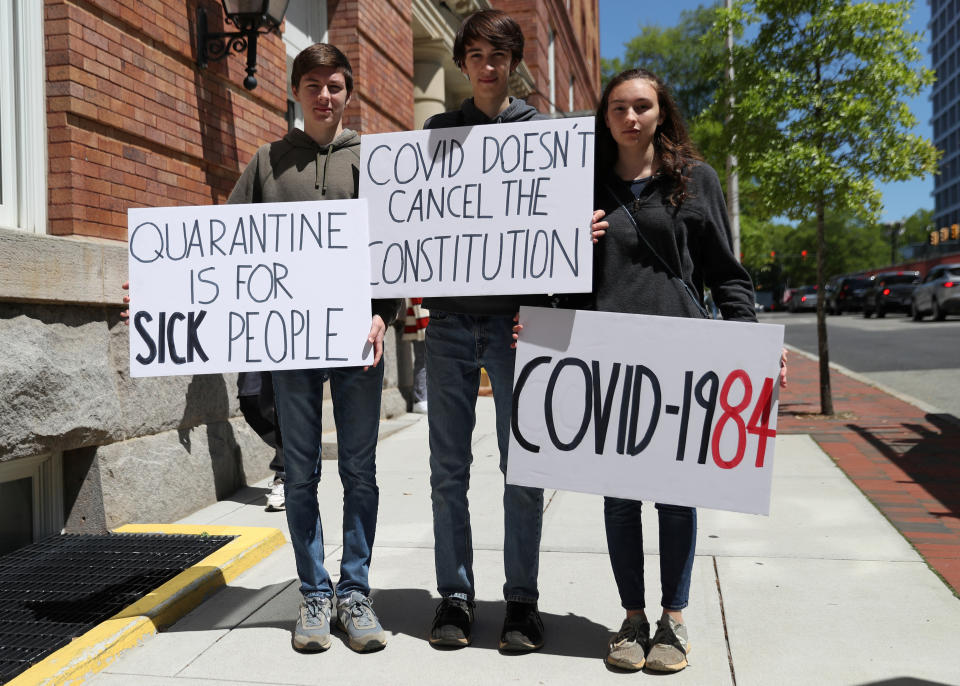 Siblings (from left to right) Tommy Kostelac, 15, Nathan Kostelac, 19, and Summer Kostelac, 17, pose for a portrait as they take part in a protest against lockdown measures put into place because of the coronavirus disease (COVID-19) outbreak and call for the reopening of the state in Richmond, Virginia, U.S., April 22, 2020. (REUTERS/Leah Millis)