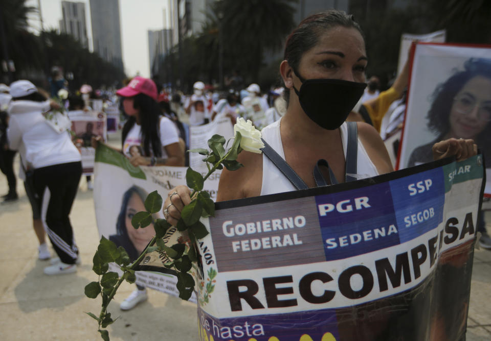 A person holds the Spanish message "Compensation" for information that would lead to the finding of a missing person, during a march in remembrance of those who have disappeared, on Mother's Day in Mexico City, Monday, May 10, 2021. (AP Photo/Fernando Llano)