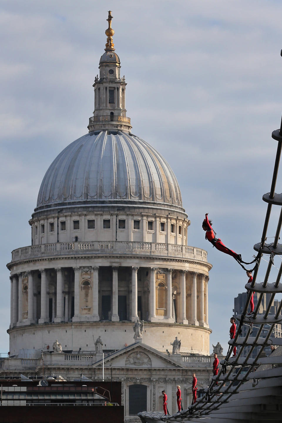 LONDON, ENGLAND - JULY 15: Dancers bungee off the Millennium Bridge as part of the 'One Extraordinary Day' performances on July 15, 2012 in London, England. The dancers are part of American choreographer Elizabeth Streb's 'extreem action' dance group which will perform around London for one day only and form part of the Cultural Olympiad. (Photo by Dan Kitwood/Getty Images)