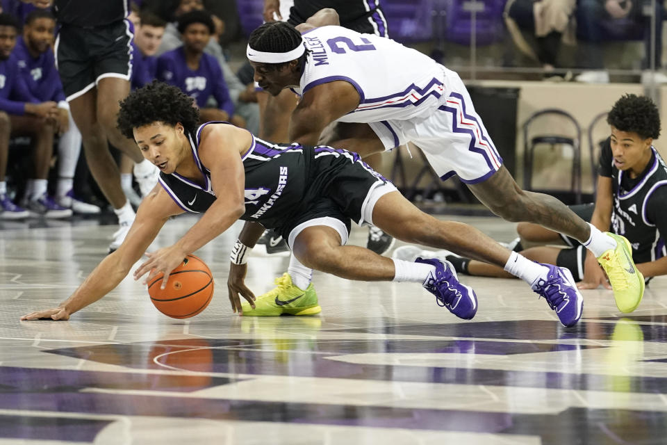 Central Arkansas guard Collin Cooper (14) and TCU forward Emanuel Miller (2) reach for the loose ball during the first half of an NCAA college basketball game in Fort Worth, Texas, Wednesday, Dec. 28, 2022. (AP Photo/LM Otero)