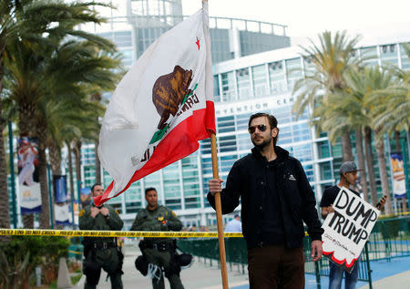 A man holds the state flag of California outside Anaheim Convention Center, where Republican U.S. Presidential candidate Donald Trump will speak at a campaign event in Anaheim, California U.S. May 25, 2016. REUTERS/Mike Blake