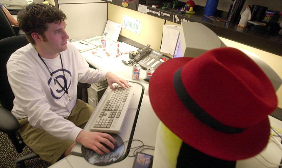 Marty Messer, with the company’s trademark red hat, works in Red Hat’s IT department in 2002 after the company moved into offices at NC State’s Centennial Campus.