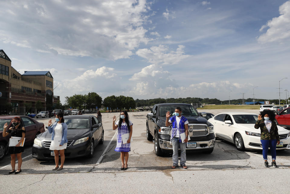 Varios inmigrantes juran lealtad a EEUU durante una ceremonia de naturalización llevada a cabo en un estacionamiento de Des Moines, Iowa, el 26 de junio del 2020. (AP Photo/Charlie Neibergall)