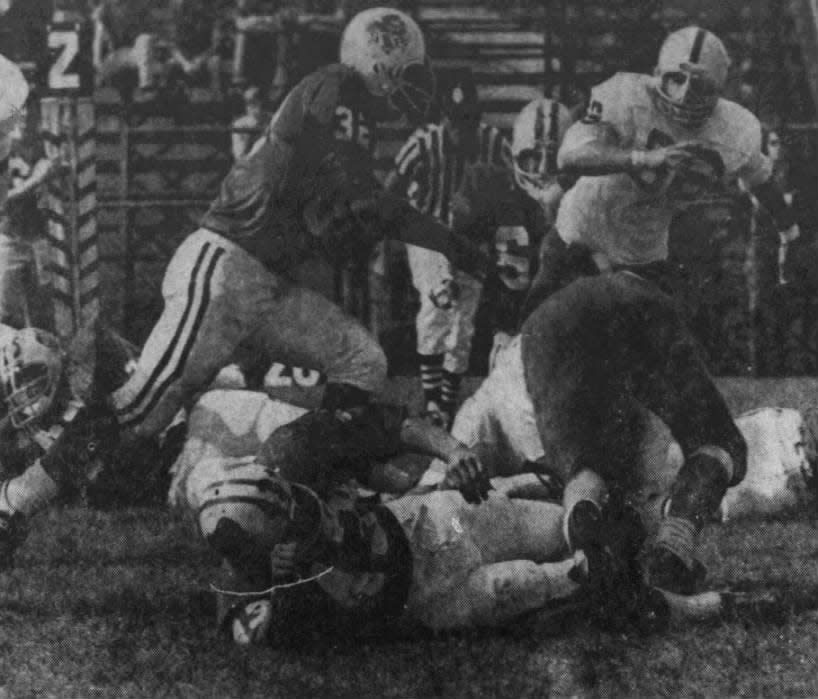Fullback Don Fiore (32) of South Plainfield High School bursts up the middle for a small gain in the first quarter of the Monday, Oct. 8, 1973, football game against John F. Kennedy High School. Kyle Curran (86) comes in to make the stop for Kennedy. Fiore scored two touchdowns as South Planfield defeated the Mustangs, 18-6.