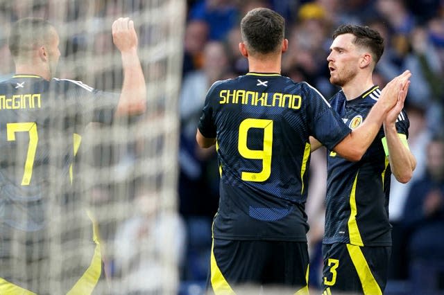 John McGinn, Lawrence Shankland and Andy Robertson, left to right, celebrate Scotland’s first goal against Finland