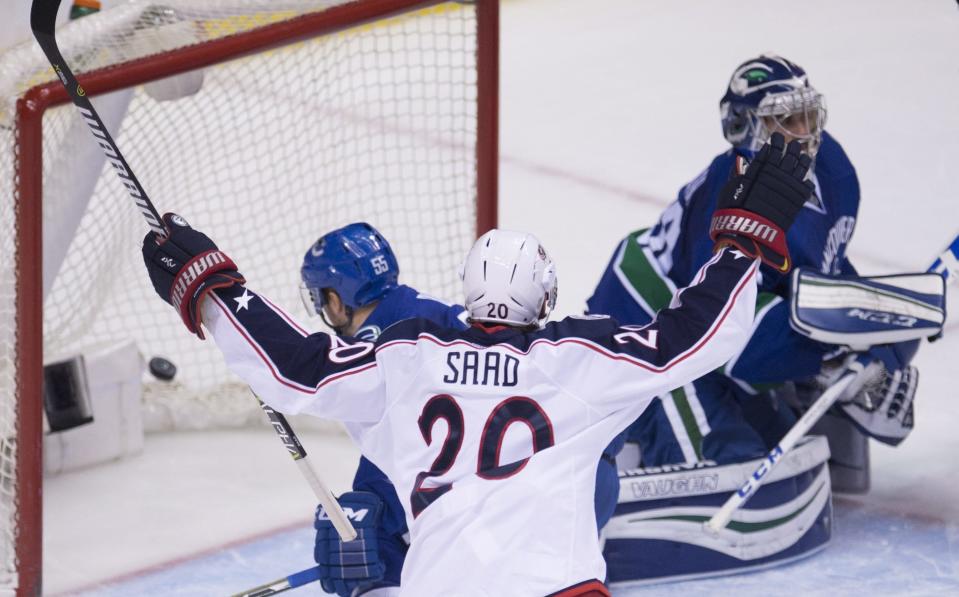 Columbus Blue Jackets left wing Brandon Saad (20) celebrates his goal past Vancouver Canucks goalie Ryan Miller (30) during the second period of an NHL hockey game, Sunday, Dec. 18, 2016 in Vancouver, British Columbia. (Jonathan Hayward/The Canadian Press via AP)