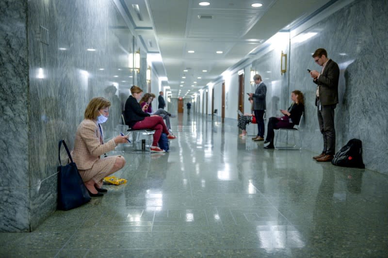 Journalists practice social distancing outside a meeting to wrap up work on coronavirus economic aid legislation