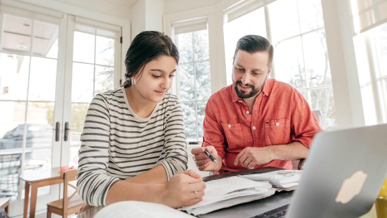 Dad helping daughter with her studies.