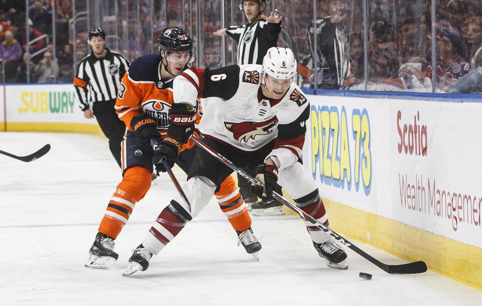Arizona Coyotes' Jakob Chychrun (6) and Edmonton Oilers' Ryan Nugent-Hopkins (93) battle for the puck during first period NHL action in Edmonton, Alberta, on Saturday Jan. 18, 2020. (Jason Franson/The Canadian Press via AP)