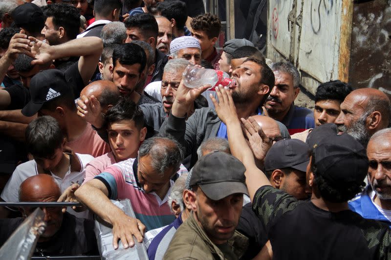 FILE PHOTO: Palestinians queue up to buy bread from a bakery in Gaza City