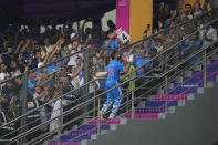 Spectators cheer as India's Virat Kohli walks back to pavilion after losing his wicket and scoring a century during the ICC Men's Cricket World Cup first semi final match between India and New Zealand in Mumbai, India, Wednesday, Nov. 15, 2023. Kohli hit his record 50th century in one-day internationals on Wednesday, surpassing the mark he shared with countryman Sachin Tendulkar. (AP Photo/Rafiq Maqbool)