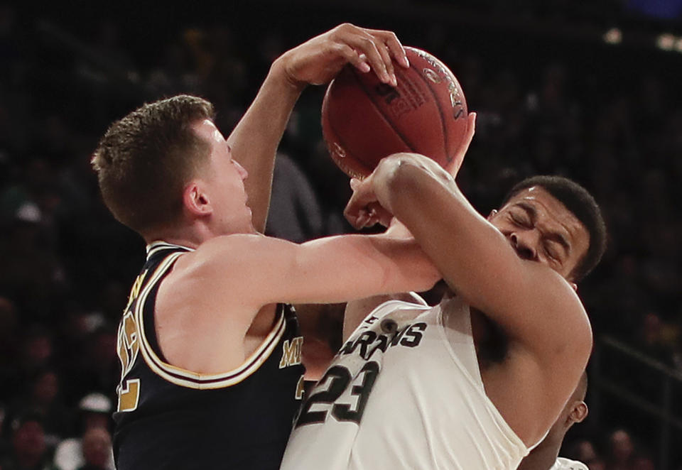 Michigan guard Duncan Robinson (22) and Michigan State forward Xavier Tillman (23) battle for a rebound during the first half of an NCAA Big Ten Conference tournament semifinal college basketball game, Saturday, March 3, 2018, in New York. (AP Photo/Julie Jacobson)