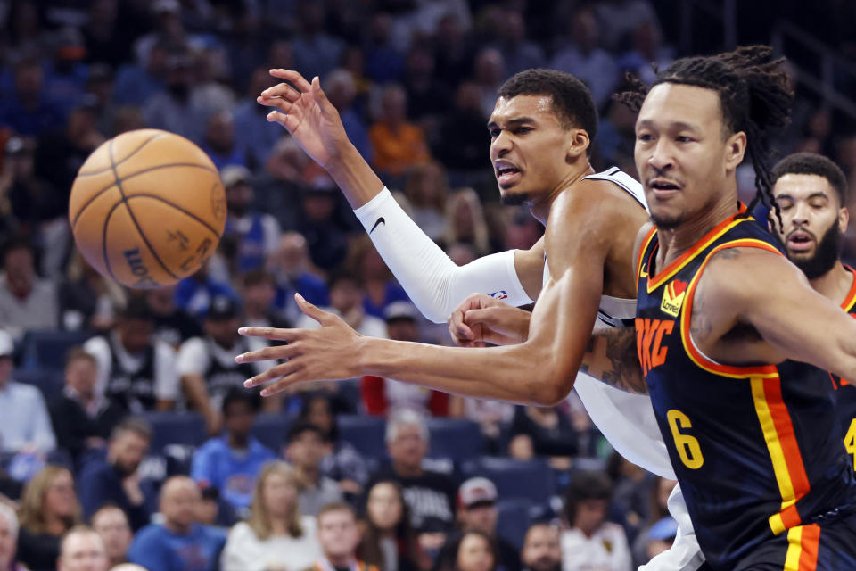 Oklahoma City forward Jaylin Williams, right, and San Antonio center Victor Wembanyama, left, chase the ball during the first half of an NBA in-season tournament basketball game Tuesday, Nov. 14, 2023, in Oklahoma City. (AP Photo/Nate Billings)