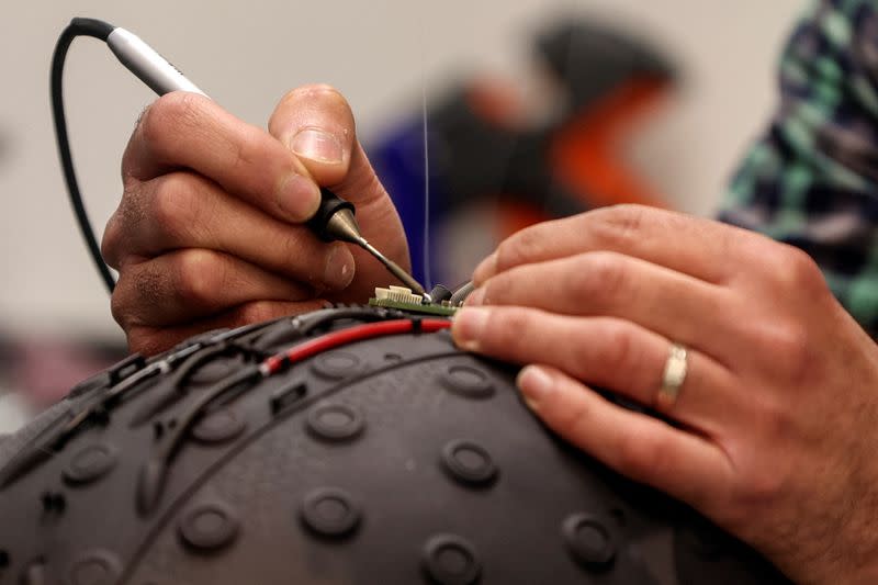 A worker at the Israeli startup Brain.Space builds an EEG enabled helmet, due to be used in an experiment on the impact of a microgravity environment on the brain activity, in Tel Aviv