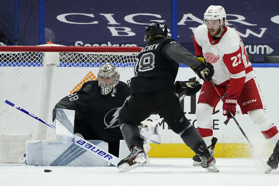 Detroit Red Wings center Michael Rasmussen (27) shoots wide of Tampa Bay Lightning goaltender Andrei Vasilevskiy (88) and defenseman Mikhail Sergachev (98) during the second period of an NHL hockey game Saturday, April 3, 2021, in Tampa, Fla. (AP Photo/Chris O'Meara)