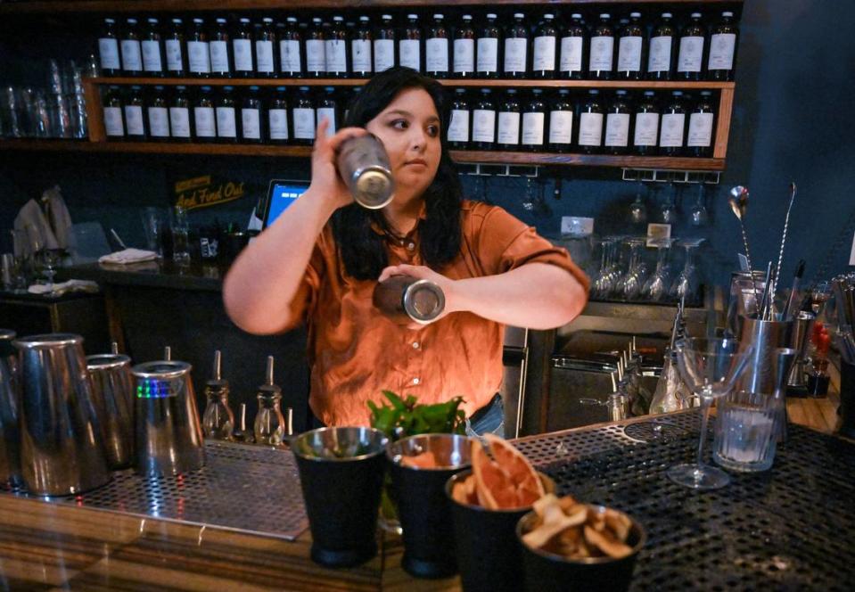 La camarera Sage Monet agita dos bebidas en Drastic Measures, un pequeño bar de cocteles del centro de Shawnee.