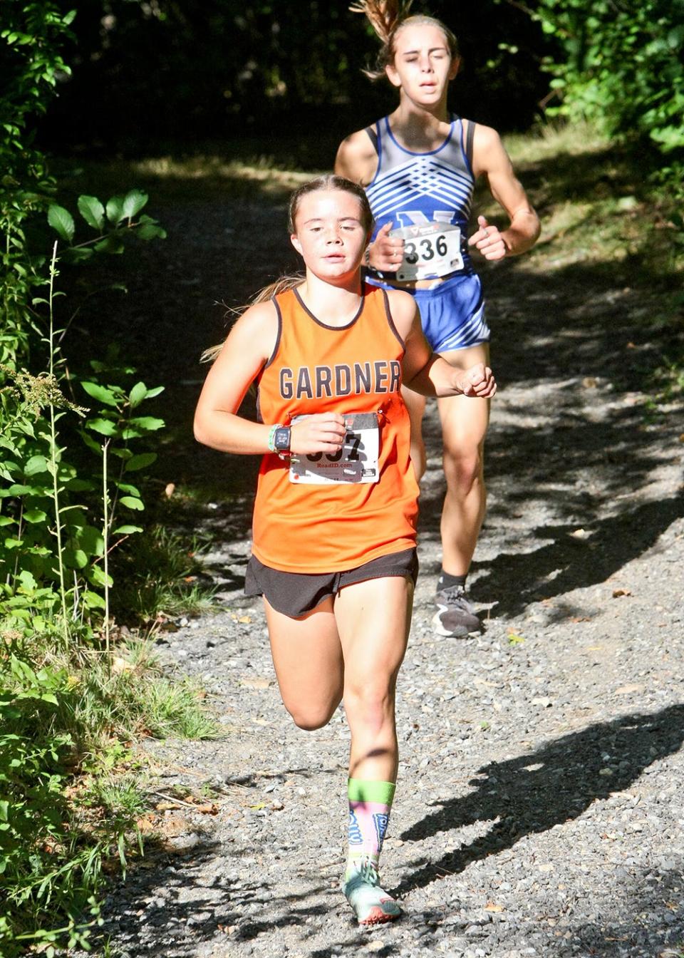 Gardner High's Krista Bettez leads Narragansett's Leah Deane through the woods during a cross-country meet in Baldwinville.