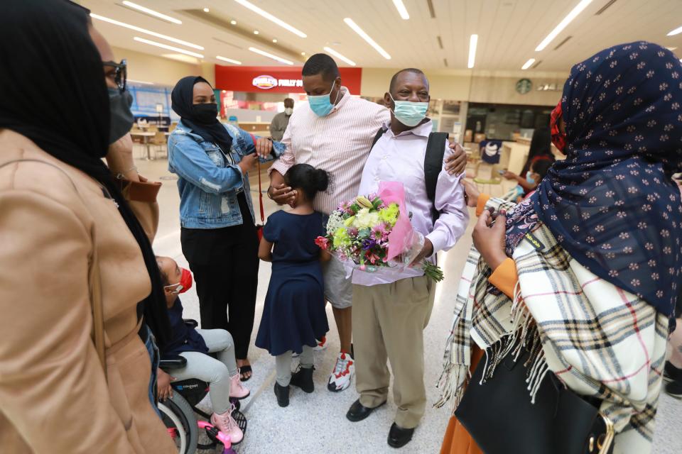 Mohamed Salem Ali admires his family moments after arriving at John Glenn International Airport in Columbus. From left is daughter Sabah Salem, 25, granddaughter Rahaf Mohammed, 5, daughter Afnan Salem, 22, son Abdelrauuf Salem, 29, granddaughter Reem Mohammed, 6, and wife Fadumo Hussien. After 11 years apart, Ali, a Somali man living in Malaysia, wasn't able to join his family in Columbus due to the Trump administration's "Muslim ban." When Biden lifted the ban earlier this year, the family got their father a visa and he arrived in Columbus Thursday morning, April 8, 2021.