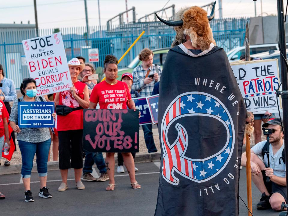 A QAnon gathering, with people holding signs saying "Count our votes"