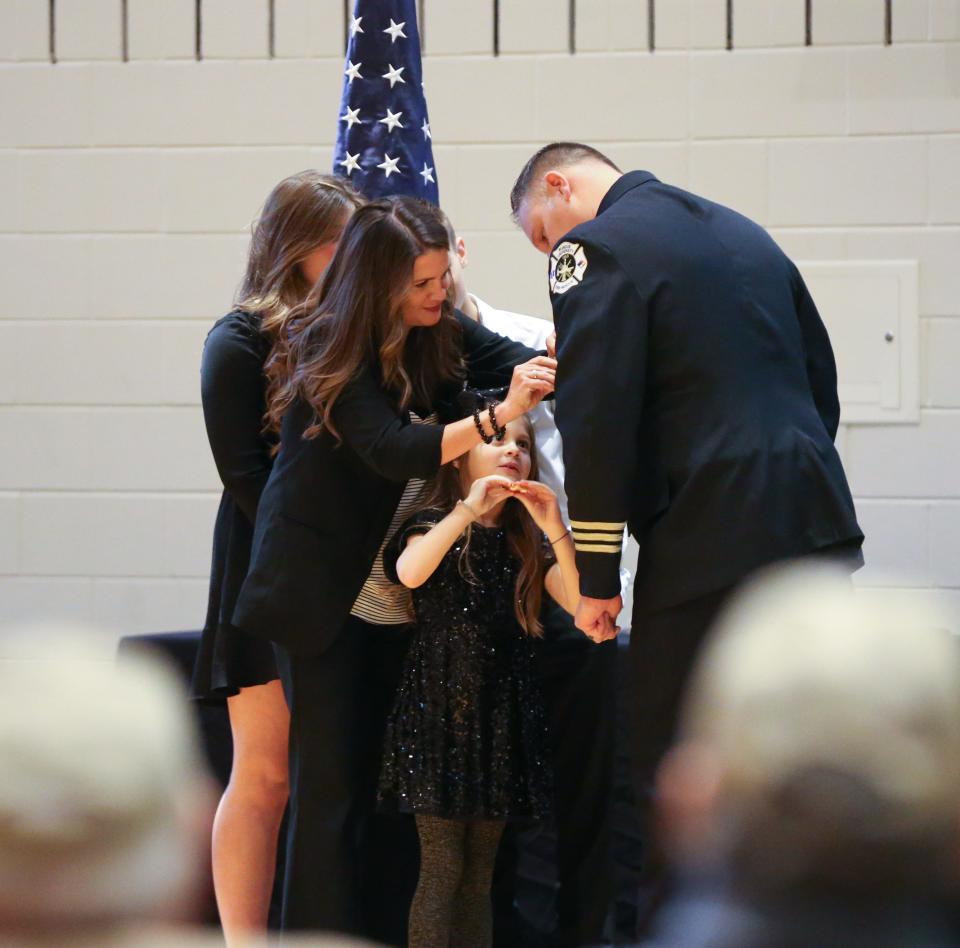 Family members of Purdue University Fire Department's incoming Fire Chief, Brad Anderson, place pins on his jacket during changing of the guard ceremony, on Wednesday, Dec. 14, 2022, in Lafayette, Ind.