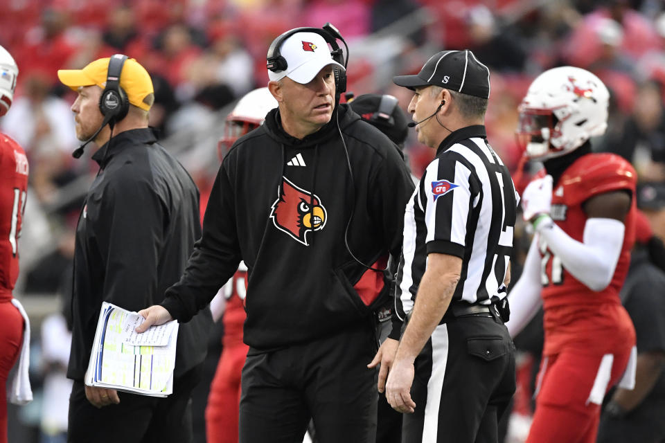Louisville head coach Jeff Brohm, center, argues with an official during the second half of an NCAA college football game against Duke in Louisville, Ky., Saturday, Oct. 28, 2023. (AP Photo/Timothy D. Easley)
