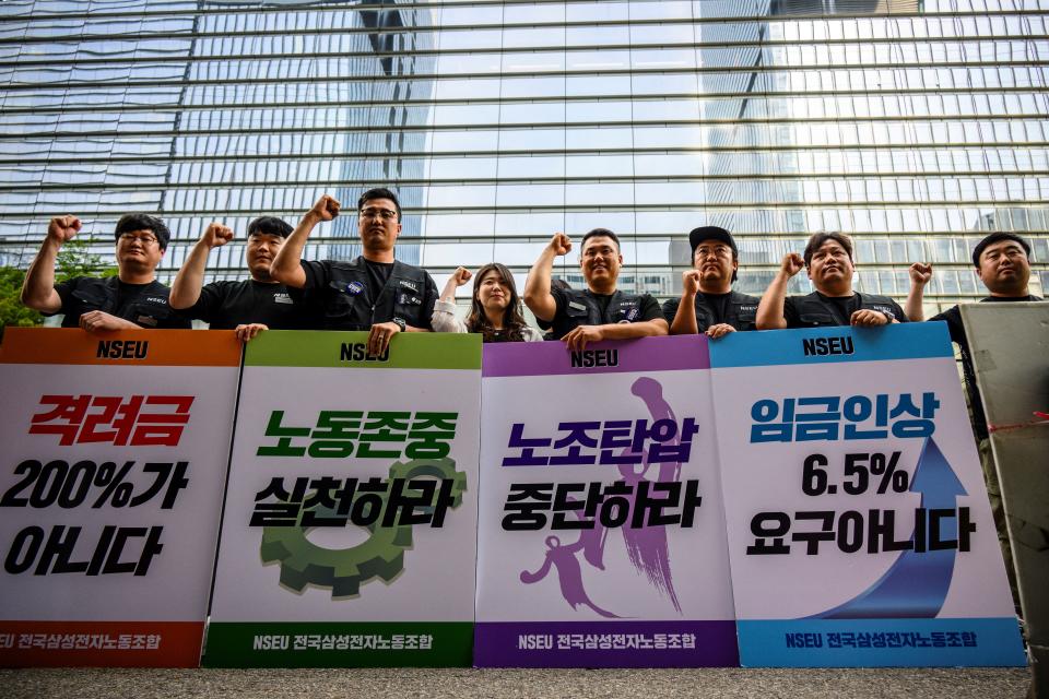 三星電子的工會成員在公司大樓外舉行的集會上舉著標語，並進行了有史以來的首次罷工。（Photo by ANTHONY WALLACE/AFP/Getty Images）